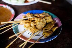 Pork satay served with dipping peanut sauce. photo