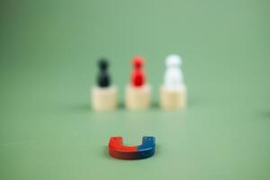 Horseshoe magnets attract three colour people from crowd. Attracting target human resources. photo