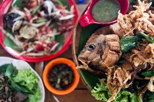 crujiente tilapia pescado cocido con hierbas, La hierba de limón, kaffir y Lima hojas con Mariscos salsas foto