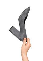 A hand holding a shoe with a pointed toe, heeled footwear, isolated on white photo