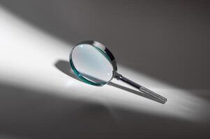 Abstract exploration of light and shadow. Silver metal glass magnifier lens zooms in on mystery. photo