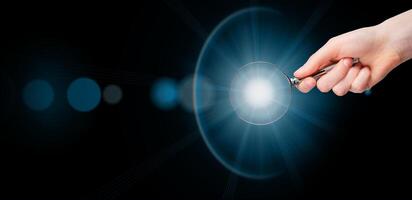 Magnifying glass in hand, light, insight. Banner background photo