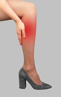 Calf pain, strain and ache on women leg in high heeled shoes photo