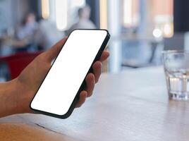 A young woman holding a smartphone, showcasing a clear, empty screen. The mockup provides space photo