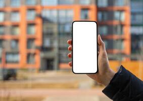 Hand holding mobile phone screen mockup, empty blank smartphone, blurred building photo