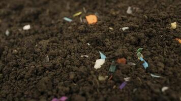 Microplastics inside the soil. Concept of plastic pollution, fertilizing and agroo industry. Non-recyclable plastic pollution in the compost at the field. Selective focus. photo