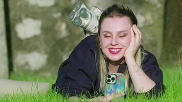 ung kvinna är använder sig av henne mobil telefon i natur video