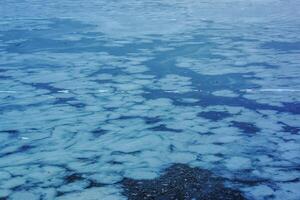 Ice surface of the river. Texture of ice shards and water. Winter background photo