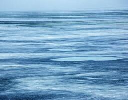 hielo superficie de el río. textura de hielo fragmentos y agua. invierno antecedentes foto