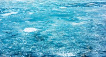 Ice surface of the river. Texture of ice shards and water. Winter background photo