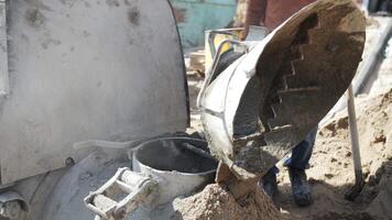 worker at a construction site mixes the mortar for floor screed in a mixer video