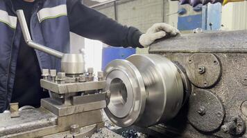 worker Trainee mastering the art of metalworking on a lathe in a workshop video