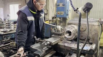 Young apprentice mastering the lathe machine in industrial workshop video