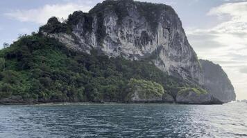 asombroso aéreo desde un barco el belleza de un lozano verde montaña isla, rodeado por reluciente aguas, ofrecimiento un maravilloso visual espectáculo video