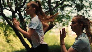 ukraina. lviv 02.08.2021 löpning två flickor stänga upp, två idrottare löpning mot en suddig stad bakgrund, morgon- jogga av Tonårs tjejer, sida se av två flicka löpare video