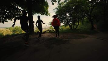 bambini correre nel il boschi, mattina correre di tre figli, uno ragazza e Due ragazzi correre, figli di mattina fare jogging, bambini correre nel il boschi, indietro Visualizza, città Visualizza video