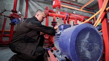 A water pumping station engineer repairs the water supply compressor engine. video