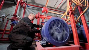 un' acqua pompaggio stazione ingegnere riparazione il acqua fornitura compressore motore. video