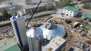 aéreo Visão voar sobre a ampla construção do a agrícola complexo. construção local. construção do instalações para armazenamento e em processamento do grão e armazenamento e Produção do biogás. video