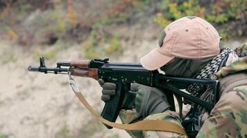 militär skjuter med en maskin pistol stänga upp. en kämpe av de amerikan trupper försiktigt syftar till på de fiende och drar de avtryckare av de maskin pistol. skott från en maskin pistol. video