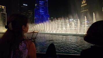 vae, Dubai - Verenigde Arabisch emiraten 01 april 2024 Dubai fontein tonen schouwspel, aftekenen toeschouwers genieten een verbijsterend fontein Scherm met verlichte stadsgezicht. video