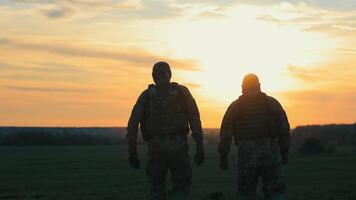 militares homens retornando depois de completando uma tarefa. soldados dentro militares uniforme andar em uma pedregoso estrada video