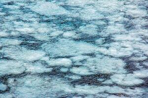 Ice surface of the river. Texture of ice shards and water. Winter background photo