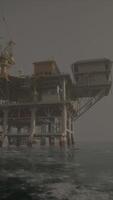 An oil rig standing tall in the middle of the vast ocean video