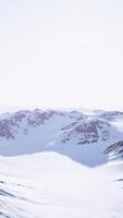 A majestic snow-capped mountain range covered in a pristine blanket of snow video