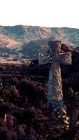 uma cemitério Cruz contra uma pano de fundo do majestoso montanhas dentro uma sereno campo video