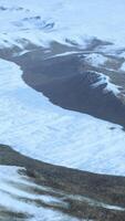 een majestueus met sneeuw bedekt berg reeks gezien van bovenstaand video