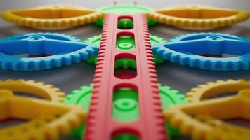 Looped animation of a group of multi-colored children plastic gears. video