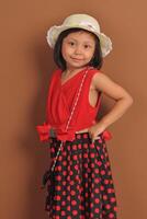 an indonesian little girl wearing fashionable dress with modeling pose. photo