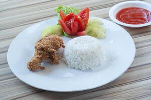 frito pollo con blanco arroz y vegetales como adornar foto