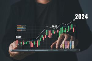 hombre toque gráficos y Progreso de negocio y analizar financiero, y inversión.online negocios, comercio electrónico, en línea marketing.uso tecnología a plan estrategia a éxito metas y crecimiento valores 2024. foto