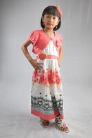 an indonesian little girl wearing fashionable dress with modeling pose. photo