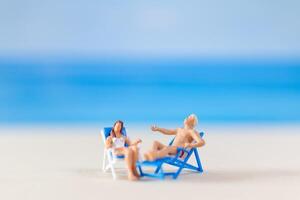 miniatura personas , Pareja relajante en playa sillas en el playa foto