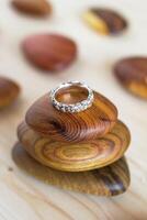 Textured silver ring on a wooden holder and soft wooden background. Handcraft precious item. Jewelry accessories. photo