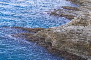 Beach, crystal clear water in Mediterranean sea near to cliff. Kemer, Turkey. photo