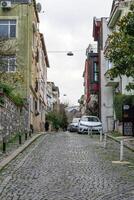 Istanbul, Turkey - December 28, 2022. Picturesque cobblestone street in Istanbul, Turkey with vibrant buildings and a person walking. photo