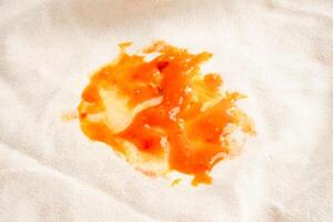 Dirty tomato sauce stain or ketchup on cloth to wash with washing powder, cleaning housework concept. photo