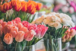 Beautiful bouquets of tulips in a glass vases in a flower shop. Blurred flower shop in a background. photo