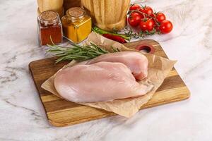 Raw chicken breast served rosemary photo