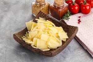 Sliced parmesan cheese in the bowl photo