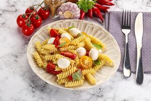 Italian pasta with mozzarella and tomato photo