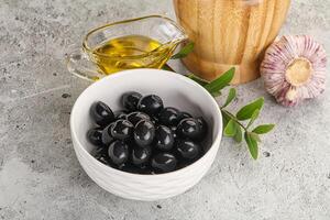Black olives with oil and branch photo