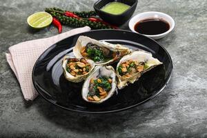 Open half oysters with green onion photo