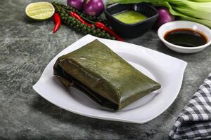 asiático cocina - arroz con relleno en plátano hoja foto