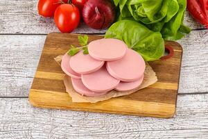 Slices boiled sausages for breakfast photo