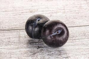 Two ripe sweet black plums photo